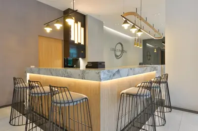 a bar with five stools in a restaurant at Grace Patong Hotel in Patong Beach