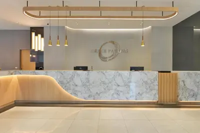 a lobby with a marble counter and a reception desk at Grace Patong Hotel in Patong Beach