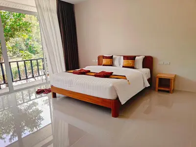 a bedroom with a bed and a large window at The mantra resort in Ko Yao Yai