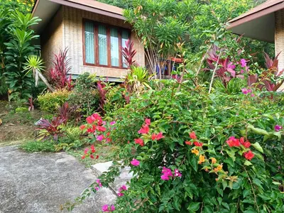 a garden with flowers in front of a house at The mantra resort in Ko Yao Yai
