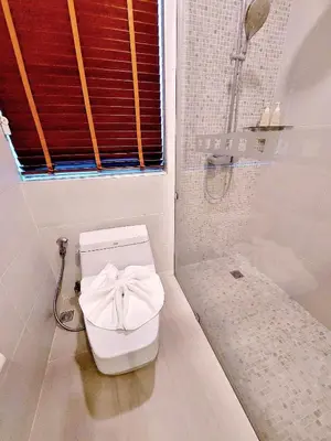 a bathroom with a toilet with a window and a shower at Aonang Phu Dahla Private Pool & Sea View - SHA Plus in Ao Nang Beach