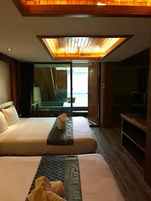 a hotel room with two beds and a television at Krabi Klong Muang Bay Resort in Klong Muang Beach
