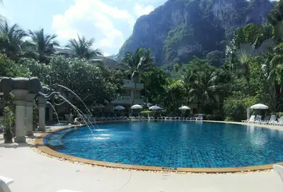 a pool with a water fountain in front of a mountain at Golden Beach Resort in Ao Nang Beach
