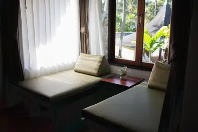 a room with a window with a bench and a table at Golden Beach Resort in Ao Nang Beach