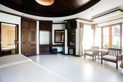 a bedroom with a bed and two chairs and a table at Golden Beach Resort in Ao Nang Beach