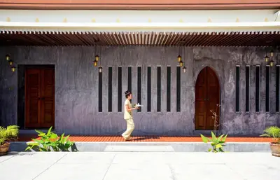 a woman walking in front of a building at Andamantra Resort and Villa Phuket in Patong Beach