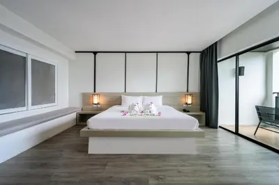 a bedroom with a large white bed with flowers on it at Andamantra Resort and Villa Phuket in Patong Beach
