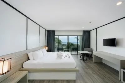 a hotel room with a bed and a television at Andamantra Resort and Villa Phuket in Patong Beach