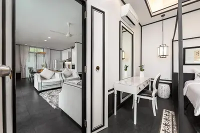 a bedroom with a bed and a living room with a table at MONO LUX Villa x MonthStayZ Thailand in Chalong