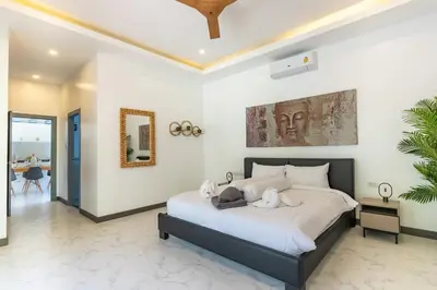 a bedroom with a large bed with white sheets at villa Akala in Ban Saiyuan (1)