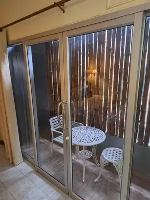 a glass door with a table and chairs on a balcony at Lalisa Hotel Aonang in Ao Nang Beach