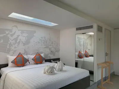 a bedroom with two beds and a painting on the wall at Tao Resort and Villas (SHA Extra+) in Phuket Town