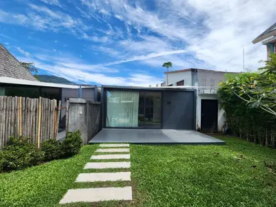 a yard with a house and a fence at Tao Resort and Villas (SHA Extra+) in Phuket Town