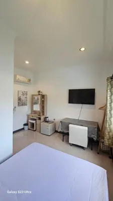 a living room with a flat screen tv on the wall at Passion Nai Harn Guesthouse in Nai Harn Beach