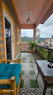 a porch with a couch and a table on a patio at Passion Nai Harn Guesthouse in Nai Harn Beach