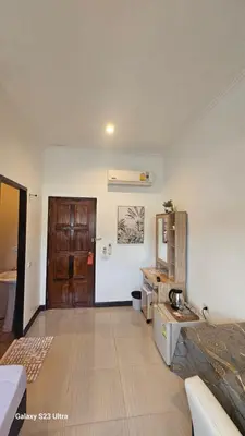 a living room with a kitchen and a room with a bed at Passion Nai Harn Guesthouse in Nai Harn Beach