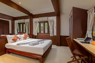 a bedroom with a bed and a desk with a computer at Nakawanna Villa in Phuket Town