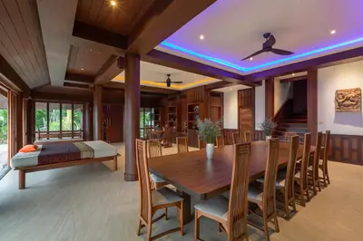 a dining room with a wooden table and chairs at Nakawanna Villa in Phuket Town