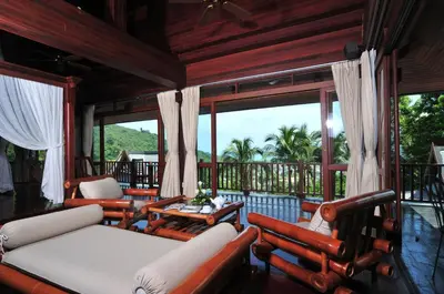 a screened in porch with couches and a table at Nakawanna Villa in Phuket Town