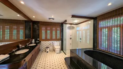 a bathroom with two sinks and a shower and a toilet at Nakawanna Villa in Phuket Town