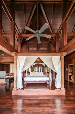 a bedroom with a bed with a ceiling fan at Nakawanna Villa in Phuket Town