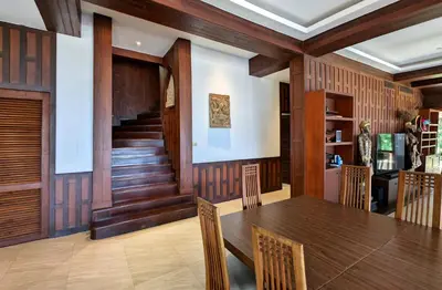 a dining room with a table and wooden walls at Nakawanna Villa in Phuket Town