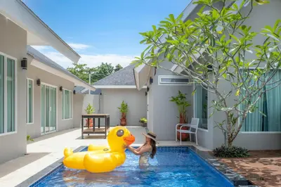 a woman is playing with a rubber duck in a pool at De palm poolvilla by KC in Ban Chin Tham Mai