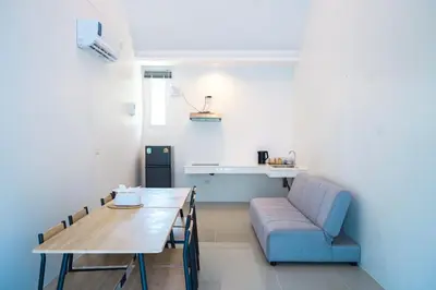 a living room with a couch and a table and a chair at De palm poolvilla by KC in Ban Chin Tham Mai