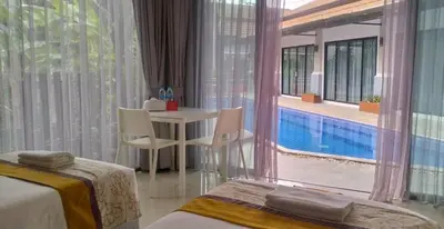 a hotel room with a pool and a table and chairs at De palm poolvilla by KC in Ban Chin Tham Mai