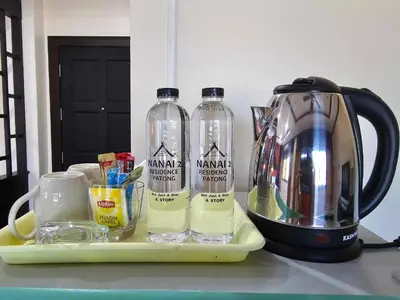 two bottles of water on a tray next to a blender at Nanai 2 Residence Patong Phuket in Patong Beach