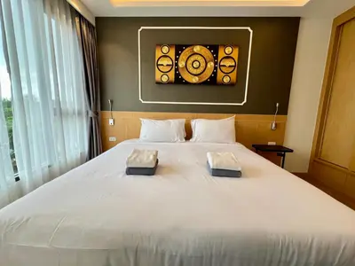 a bedroom with a white bed with two pillows on it at Aristo 2 Phuket by RESAVA in Surin Beach