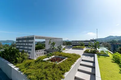 a view of a building with a garden at Aristo 2 Phuket by RESAVA in Surin Beach