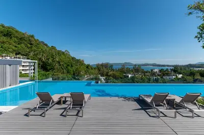 a group of chairs sitting next to a swimming pool at Aristo 2 Phuket by RESAVA in Surin Beach