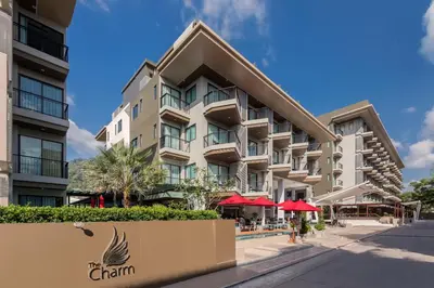 a building with red umbrellas in front of it at The Charm Resort Phuket in Patong Beach