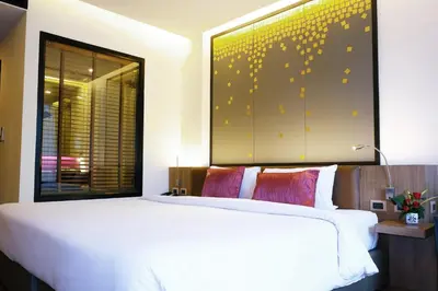 a bedroom with a large white bed and a window at The Beach Heights Resort SHA Plus in Kata Beach