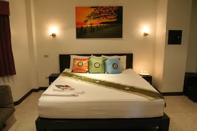 a bedroom with a large bed with pillows at Angus O'Tool's Guesthouse in Karon Beach