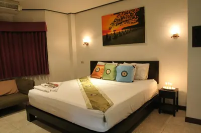 a bedroom with a large bed with pillows at Angus O'Tool's Guesthouse in Karon Beach