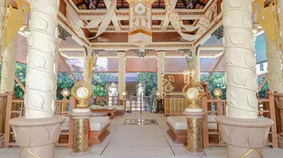 a room with columns and chairs in a building at Quality Beach Resorts and Spa Patong in Patong Beach