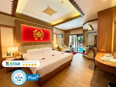a hotel room with a bed and a desk at Quality Beach Resorts and Spa Patong in Patong Beach