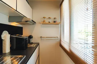 a kitchen with a sink and a window with blinds at Private apartment at Bayshore by Lofty in Patong Beach