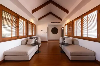 a living room with two couches and windows at Laguna Links Golf View Villa- Bangtao Beach in Phuket Town