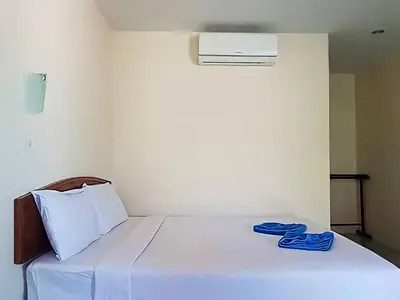 a white bed with blue slippers sitting on it at Dalum Beachhouse in Phi Phi Don