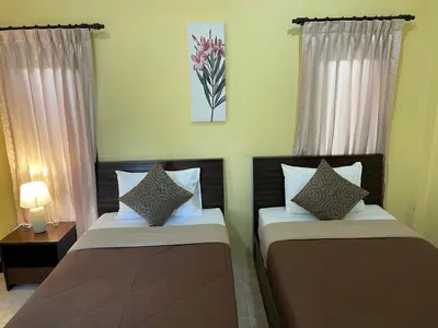 two beds sitting next to each other in a room at Ron Bungalow in Bang Tao Beach
