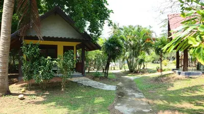 a small house with a pathway next to trees at Koh Yao Noi Beach Resort in Ko Yao Noi