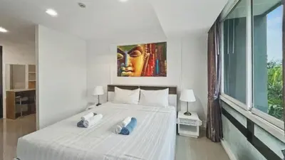 a bedroom with a large white bed with two pillows at Kris - Modern Spacious 2 Bedrooms Condo with Pool in Patong Beach