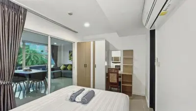 a bedroom with a bed and a living room at Kris - Modern Spacious 2 Bedrooms Condo with Pool in Patong Beach