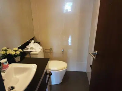 a bathroom with a white toilet and a sink at Kris - Modern Spacious 2 Bedrooms Condo with Pool in Patong Beach