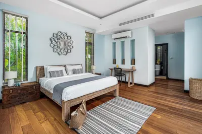 a bedroom with a large bed and a table at Tropical 3BR Holiday Villa with Pool, BBQ, and Shaded Patio within Walking Distance to Bang Tao Beach in Bang Tao Beach