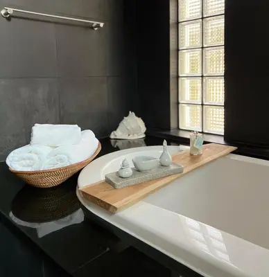 a bathroom with a bath tub with towels and a sink at Tropical 3BR Holiday Villa with Pool, BBQ, and Shaded Patio within Walking Distance to Bang Tao Beach in Bang Tao Beach