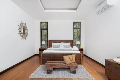 a bedroom with a bed and a table and a chair at Tropical 3BR Holiday Villa with Pool, BBQ, and Shaded Patio within Walking Distance to Bang Tao Beach in Bang Tao Beach